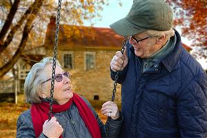 Mujer y hombre de la tercera edad en un columpio